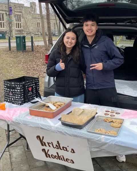 Krista and a friend selling cookies at a campus bake sale